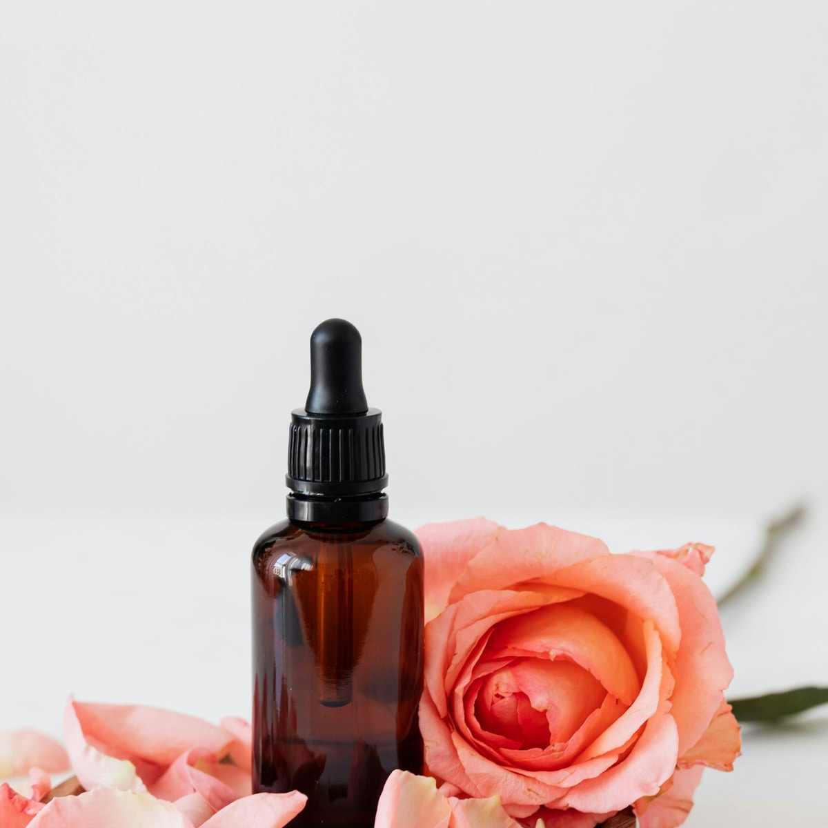Cosmetic bottles and rose arranged to represent effective skincare ingredients
