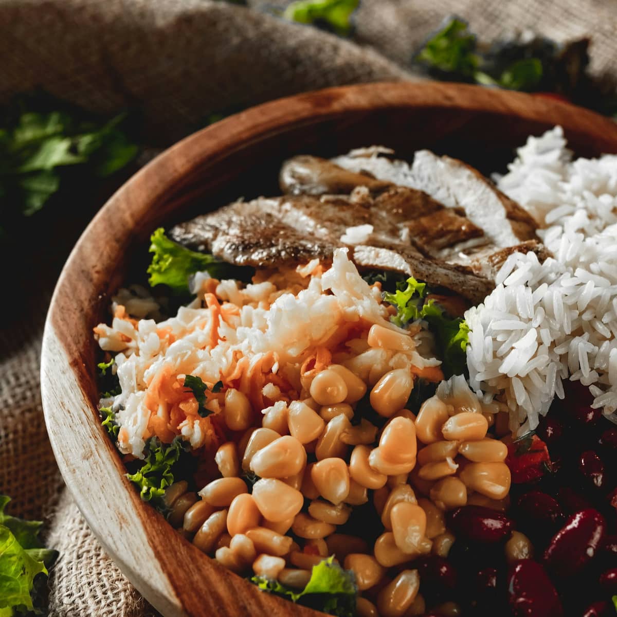 Healthy dinner bowl with chicken, rice, beans, and corn prepared for a quick weeknight meal