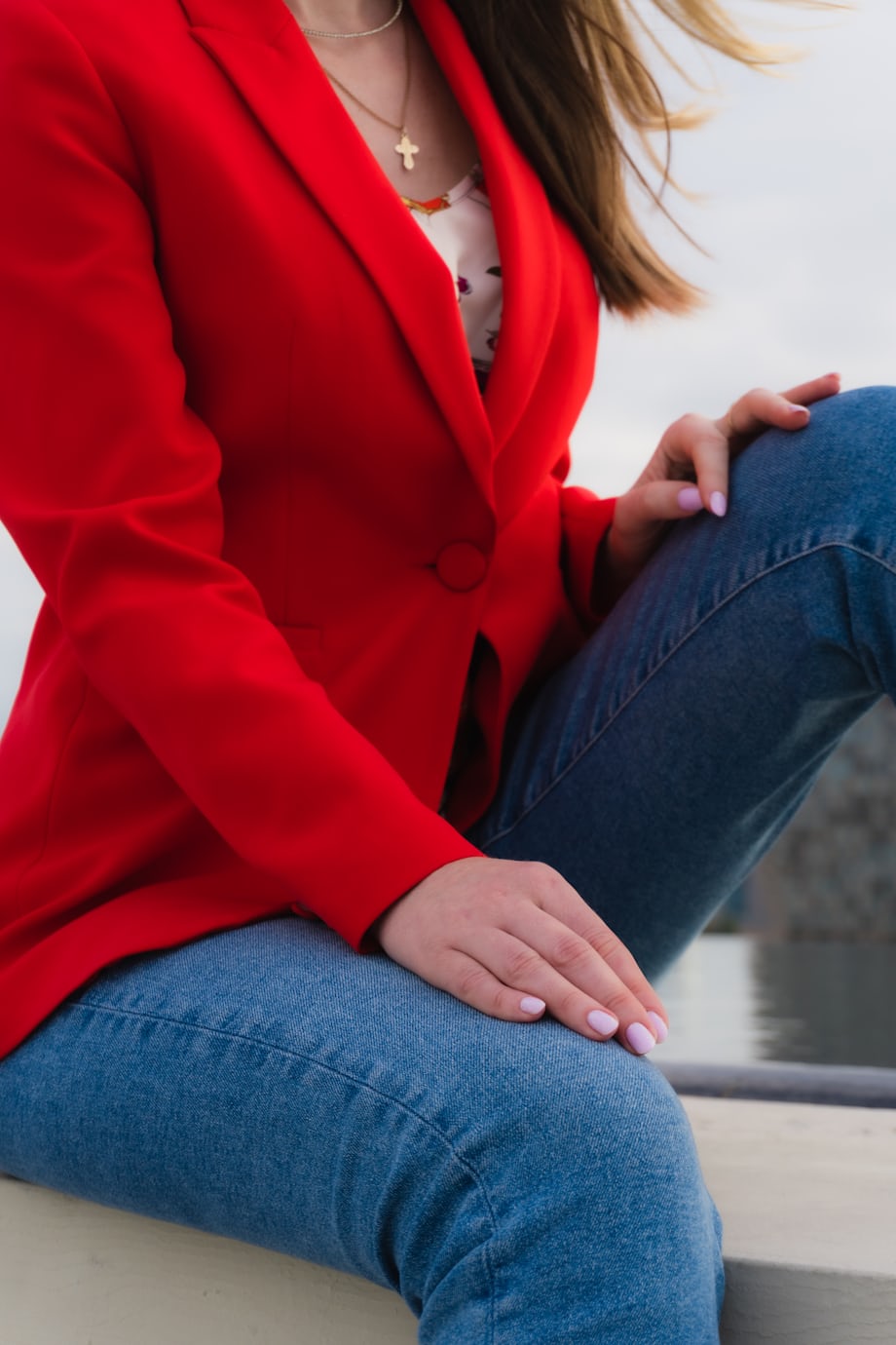Woman in red blazer and jeans showing polished celebrity-inspired casual style