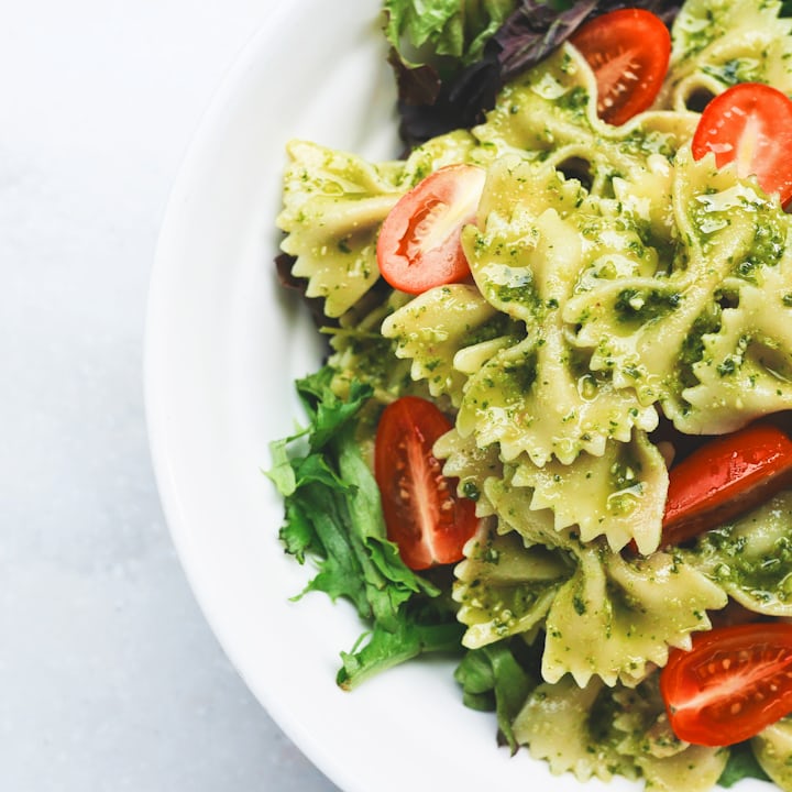 Appetizing close-up pasta plate with tomato sauce and herbs under warm light