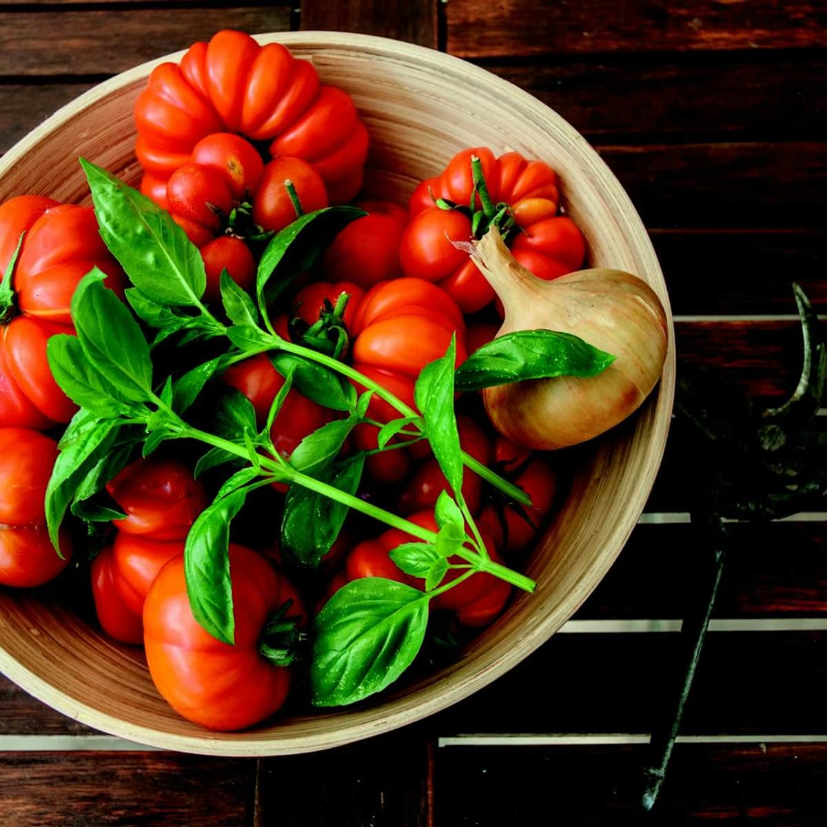 Fresh bowl of tomatoes, onions, and basil representing skin-friendly whole foods