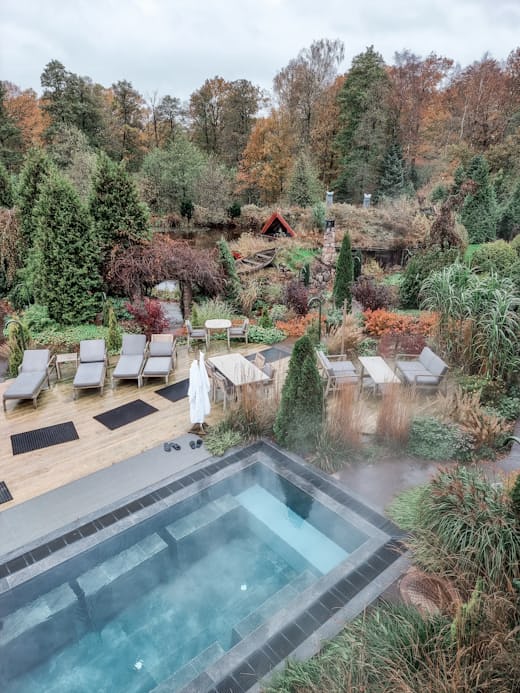Outdoor spa pool surrounded by forest at a wellness retreat