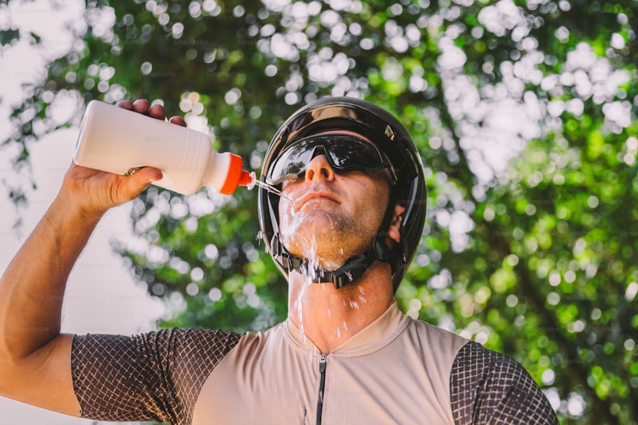 Cyclist cooling down with water after intense exercise