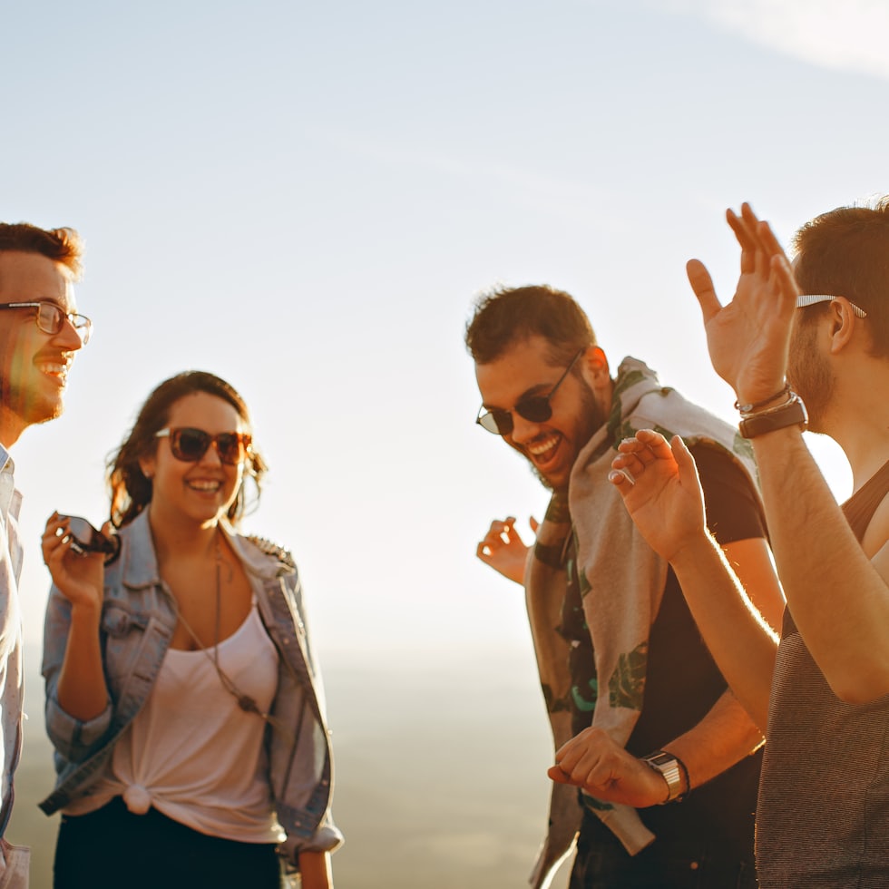 Friends laughing together at a table showing social connection and positive emotion