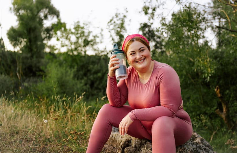 Woman holding a water bottle after workout recovery